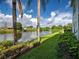 The backyard features lush landscaping, a beautiful lake, blue skies and palm trees at 5725 Greenwood Ave # 5103, North Port, FL 34287