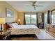 Sun-filled bedroom boasts a ceiling fan, a window and glass doors, plus a decorative rug at 5725 Greenwood Ave # 5103, North Port, FL 34287