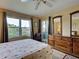 Bedroom with view of the water has a ceiling fan, large windows and light, wood flooring at 5725 Greenwood Ave # 5103, North Port, FL 34287
