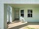 Inviting covered entrance with mint-green exterior, stylish wall lamp, and convenient small table near the door at 5725 Greenwood Ave # 5103, North Port, FL 34287