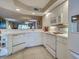Clean kitchen with white cabinets and appliances, and an open view to the living room at 5725 Greenwood Ave # 5103, North Port, FL 34287