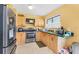 Functional kitchen featuring stainless steel appliances, light wood cabinetry, and a bright window at 5983 Hobhill Ave, North Port, FL 34287