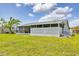 Backyard view of screened in porch and well-maintained lawn, perfect for outdoor entertaining at 5983 Hobhill Ave, North Port, FL 34287