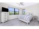 Bright bedroom with large windows overlooking the lake, stylish ceiling fan, and tile flooring at 609 Monaco Dr, Punta Gorda, FL 33950