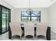 Elegant dining room features a modern chandelier and expansive windows offering views of the outdoors at 609 Monaco Dr, Punta Gorda, FL 33950