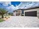 Attractive home exterior with paver driveway, lush landscaping, and 2 car garage at 609 Monaco Dr, Punta Gorda, FL 33950