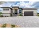 Inviting home featuring stone accents, a paver driveway, and well-manicured landscaping at 609 Monaco Dr, Punta Gorda, FL 33950