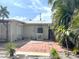 Backyard patio with brick pavers, a metal roof, tropical foliage, and an air conditioning unit at 617 W Olympia Ave, Punta Gorda, FL 33950