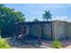 Backyard featuring a pergola with seating, surrounded by lush tropical plants and a brick paver patio at 617 W Olympia Ave, Punta Gorda, FL 33950