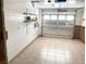 Clean garage with tile flooring, painted walls, shelving and an exterior-facing garage door at 617 W Olympia Ave, Punta Gorda, FL 33950
