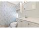 Bright bathroom with a white vanity, mirror, and a toilet with a patterned shower curtain at 6382 Cutler Ter, Port Charlotte, FL 33981