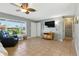 Bright living room with tile floors, gray walls, a ceiling fan, and a large window at 6382 Cutler Ter, Port Charlotte, FL 33981