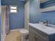 Bathroom with blue walls, a shower, and a gray vanity with a sink at 6483 Fabian Rd, North Port, FL 34287