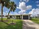 Charming single-story home boasting a lush, landscaped front yard and a long driveway leading to a garage at 6483 Fabian Rd, North Port, FL 34287