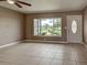 Bright living room featuring tile flooring, a ceiling fan, and a large window with a view at 6483 Fabian Rd, North Port, FL 34287