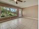 Sunlit living room with tile floors, a ceiling fan, and a large window showcasing the exterior at 6483 Fabian Rd, North Port, FL 34287