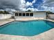 Backyard pool and patio with a white fence, offering a private space for relaxation at 6483 Fabian Rd, North Port, FL 34287