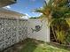 Private side yard with decorative concrete block fence, gate, and lush tropical foliage at 6483 Fabian Rd, North Port, FL 34287