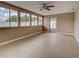 Light-filled sunroom with neutral paint, tile flooring, a ceiling fan, and several large windows at 6483 Fabian Rd, North Port, FL 34287