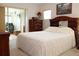 Cozy bedroom with plush bedspread, wood furniture, and natural light from the room next door at 6689 Gasparilla Pines Blvd, Englewood, FL 34224