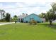 A light-blue single-story home with well-manicured lawn and landscaped garden at 6689 Gasparilla Pines Blvd, Englewood, FL 34224
