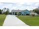 Charming single-story home with a well-maintained lawn, complemented by a long, patterned driveway at 6689 Gasparilla Pines Blvd, Englewood, FL 34224