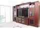 Living room featuring a large entertainment center and view of lanai at 6689 Gasparilla Pines Blvd, Englewood, FL 34224