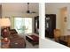 Cozy living room with ceiling fan, plush sofa, TV, and view of lanai at 6689 Gasparilla Pines Blvd, Englewood, FL 34224