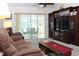 Comfortable living room with ceiling fan, plush sofa, TV, and view of lanai at 6689 Gasparilla Pines Blvd, Englewood, FL 34224