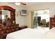 This is a main bedroom with dark-wood furniture including a dresser and a mounted television at 6689 Gasparilla Pines Blvd, Englewood, FL 34224