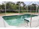 An enclosed pool features a small step-in area and a silver-colored handrail at 6689 Gasparilla Pines Blvd, Englewood, FL 34224