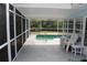 Relaxing screened-in lanai with a sparkling pool and comfortable seating area at 6689 Gasparilla Pines Blvd, Englewood, FL 34224
