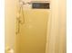 Shower stall featuring a handheld shower head, a window for natural light, and bright yellow tiles at 6689 Gasparilla Pines Blvd, Englewood, FL 34224