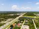 An aerial view shows the home's location near a main road with lush, green landscaping around the neighborhood at 8081 Dimstead St, Port Charlotte, FL 33981