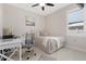 Cozy bedroom with neutral tones, features a ceiling fan and a work area with desk at 8081 Dimstead St, Port Charlotte, FL 33981