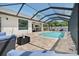 Screened-in pool area featuring brick pavers and lounge seating under an airy screened enclosure at 8081 Dimstead St, Port Charlotte, FL 33981