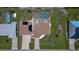 Aerial view of the roof of a single-story home with a screen-enclosed pool, solar panels, and a two car garage at 871 Columbia St, Port Charlotte, FL 33948