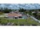 Backyard aerial view of a single-story home with a screened pool and a well manicured yard with garden beds at 871 Columbia St, Port Charlotte, FL 33948