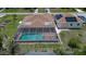 Aerial view of a single-story home's roof with a screened pool, attached garage, and solar panels on the roof at 871 Columbia St, Port Charlotte, FL 33948