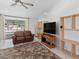 Bright living room with tile floors, a comfortable sofa, and a large window at 871 Columbia St, Port Charlotte, FL 33948