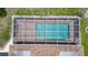 Aerial close up of the screen enclosed in-ground swimming pool with clear blue water at 871 Columbia St, Port Charlotte, FL 33948