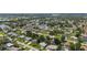 Wide aerial shot highlights a neighborhood with well-spaced houses surrounded by green spaces and distant high rises at 879 E Seminole Dr, Venice, FL 34293