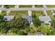 Overhead view features a home with a driveway and verdant surroundings, adjacent to other residential properties at 879 E Seminole Dr, Venice, FL 34293