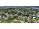 Expansive aerial view showcases a residential community dotted with homes, mature trees, and a serene pond at 879 E Seminole Dr, Venice, FL 34293