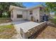 Backyard with a concrete patio, exterior access door, and a stucco exterior at 879 E Seminole Dr, Venice, FL 34293