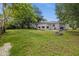 A spacious backyard with a stucco exterior, green lawn, and mature trees for outdoor enjoyment at 879 E Seminole Dr, Venice, FL 34293