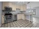 Well-lit kitchen with stainless steel appliances, light wood cabinets, and stylish tile flooring at 879 E Seminole Dr, Venice, FL 34293