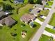 A high-angle shot exhibits a residence with an expansive lawn and mature trees in a quiet setting at 1275 Blue Lake Cir, Punta Gorda, FL 33983