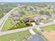 An aerial view showcases a charming home with a well-manicured lawn surrounded by lush greenery at 1275 Blue Lake Cir, Punta Gorda, FL 33983