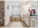 Elegant bathroom features a soaking tub with tile surround and a vanity with granite countertop at 1275 Blue Lake Cir, Punta Gorda, FL 33983